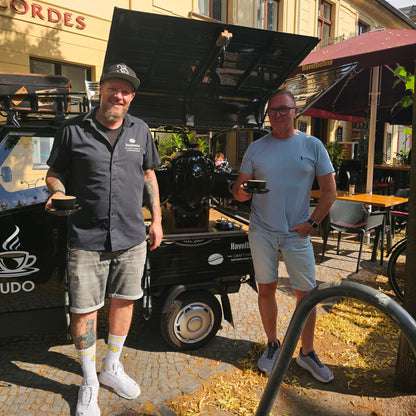 Barista und Gast mit Kaffeetassen vor der mobilen Kaffee Ape vor der Havelbohne in Potsdam