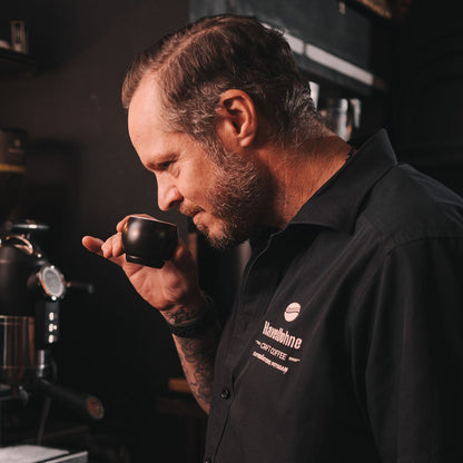 Matthias Lincke riecht an einer frisch gebrühten Tasse Espresso an der Espressomaschine.